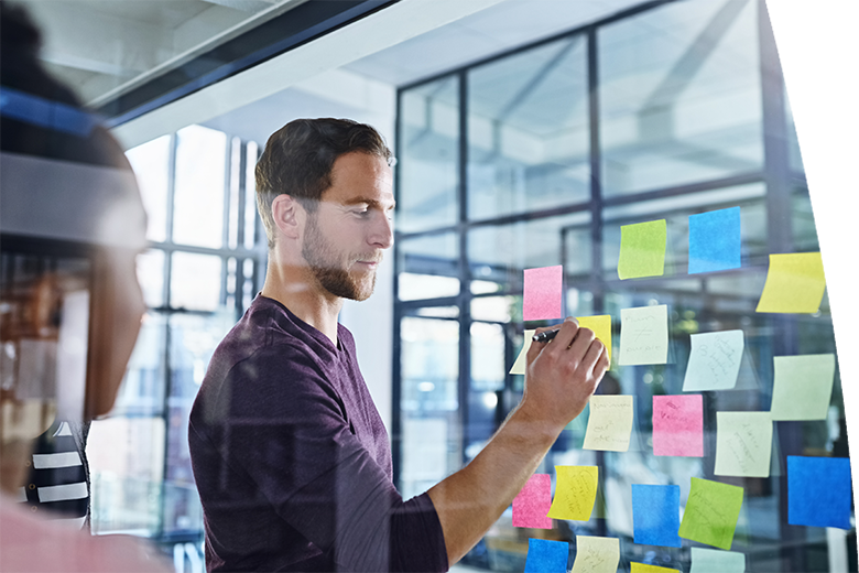 Business people, planning and writing on sticky note for ideas, solution and scrum or agile of creative project. Public relations leader with training, presentation or teamwork for workflow on glass